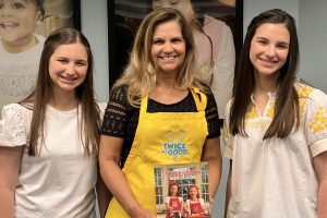 Hadley and Delany pose with their cookbook at a charity event